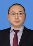 A person wearing glasses and a suit

Description automatically generated